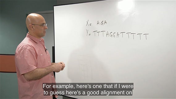 A man in front of a whiteboard with the text for here is a good number, presenting information to an audience.