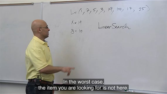 A man is positioned in front of a whiteboard, preparing to share information and facilitate a discussion.
